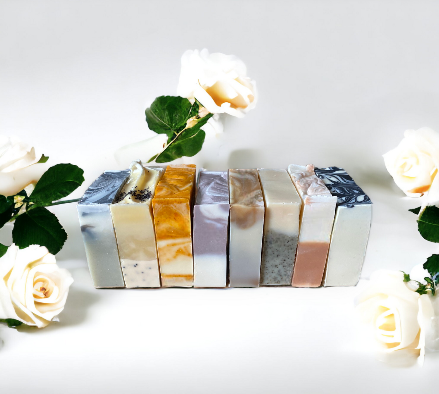 Row of natural soap bars with white roses in the background, highlighting handmade skincare products.